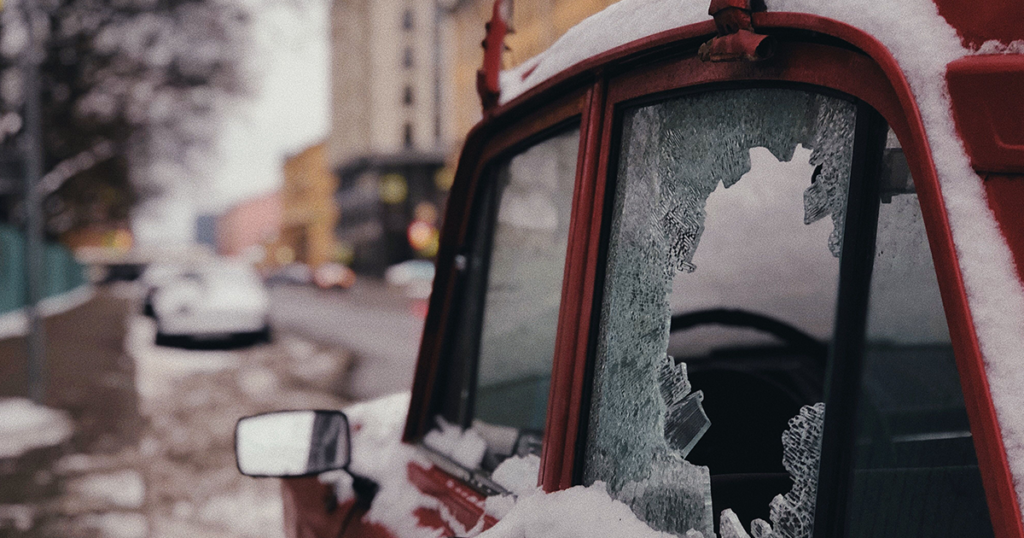 A red car with a smashed wondow