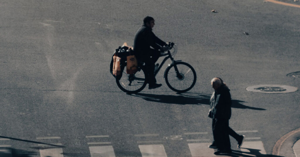 a pedestrian and a cyclist on a zebra crossing