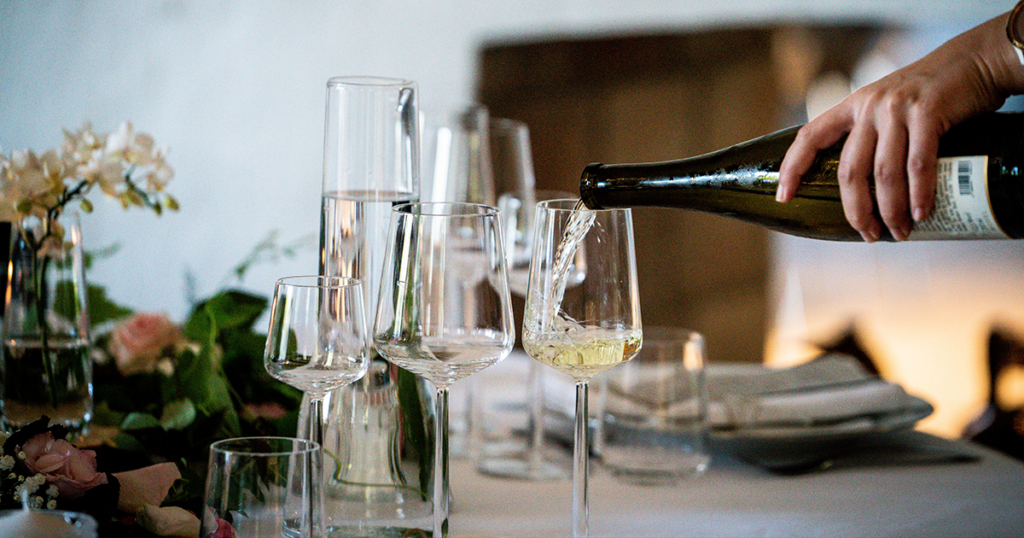a selection of wine glasses and someone pouring a glass