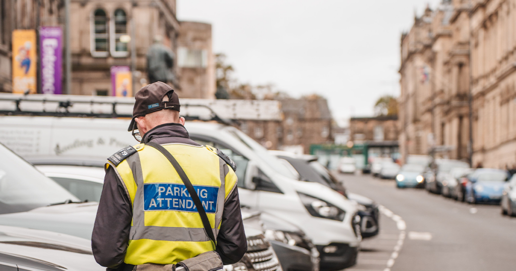 A parking attendant issuing a fin