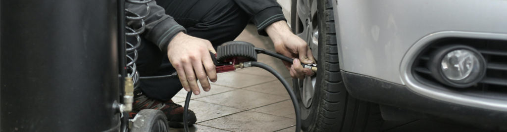 Close-up picture of mechanic pumping-up a tyre